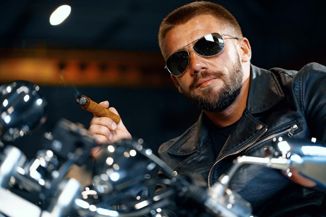 A man in sunglasses smoking a cigar on a motorcycle