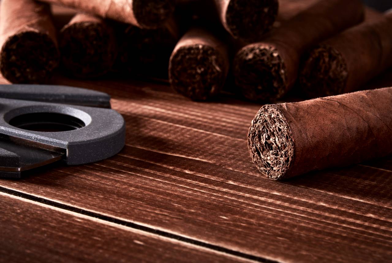kubanska cigarrer och skärare på gamla träskiva bord