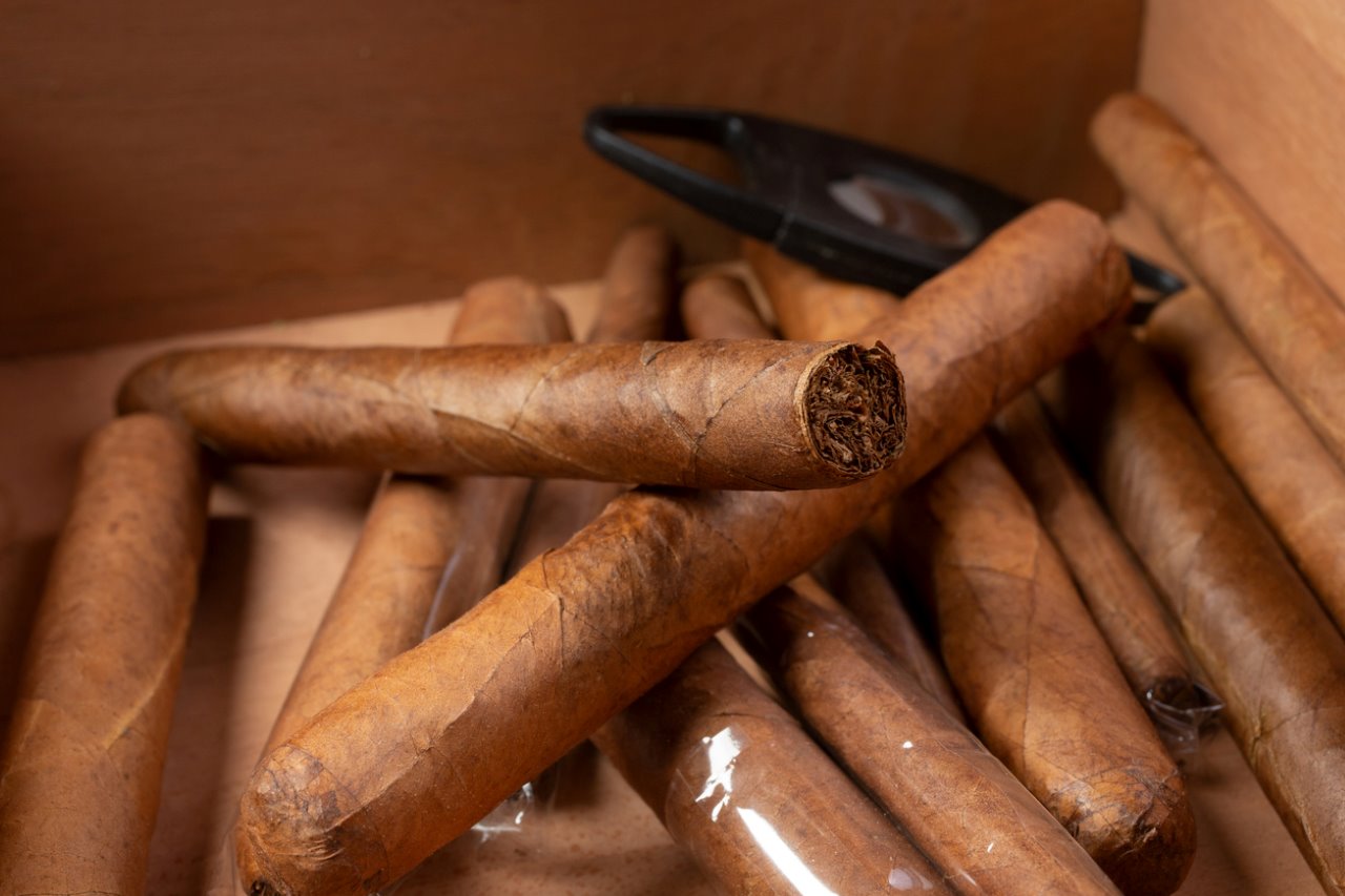 מבט מקרוב של ערימת סיגרים בקופסת עץ